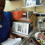 A nurse monitors a baby receiving CPAP treatment
