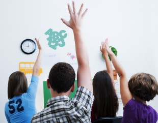 Students in Classroom Setting, Hands Eagerly Raised