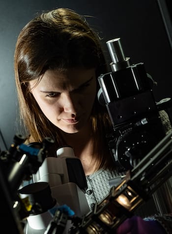 Rice University graduate student Lauren McCarthy adjusts the polarizer she used to discover a fundamentally different form of light-matter interaction in their experiments with gold nanoparticles. (Credit: Jeff Fitlow/Rice University)
