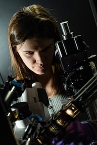 Rice University graduate student Lauren McCarthy adjusts the polarizer she used to discover a fundamentally different form of light-matter interaction in their experiments with gold nanoparticles. (Credit: Jeff Fitlow/Rice University)
