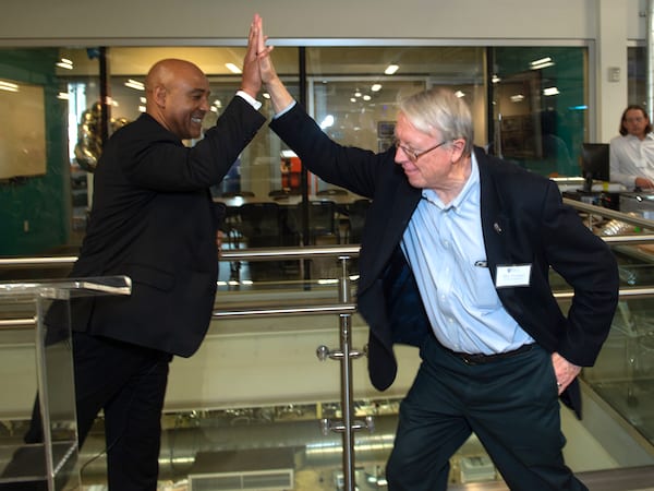 Reginald DesRoches, the William and Stephanie Sick Dean of Engineering, left, get a high-five from his predecessor, Ned Thomas, at the OEDK party. Photo by Jeff Fitlow