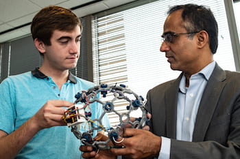 Rice University engineering student Andres Gomez and Dr. Nitin Tandon of the McGovern Medical School at The University of Texas Health Science Center at Houston hold a cap with sensors used to develop a wireless monitor that records seizure data from patients with intractable epilepsy. (Credit: Jeff Fitlow/Rice University)