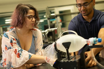 Engineering students Natalie Dickman and Aravind Sundaramraj adjust their automated bag valve mask device at Rice University's Oshman Engineering Design Kitchen. (Credit: Jeff Fitlow/Rice University)