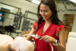 Rice University engineering student Carolina De Santiago sets up a mannequin to receive air from the automated bag valve mask device she and her teammates designed and built. The team hopes its work will help save lives where and when ventilators are not available. (Credit: Jeff Fitlow/Rice University)