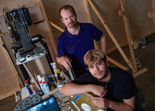 Rob Blumrick and Wiess College junior Agustin Carrizales Jr. in the projection booth at the Moody Center. (Photo by Jeff Fitlow)