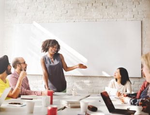 Woman presenting to boss and coworkers at meeting. Photo credit: 123rf.com.