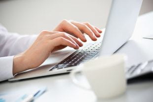 Close-up of person making an online purchase.  Photo by 123rf.com.