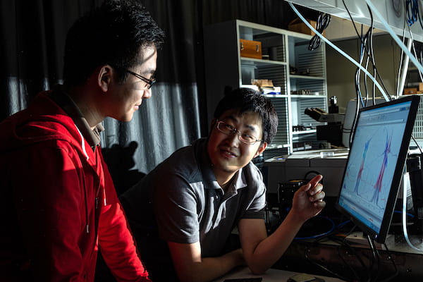 Rice University graduate student Xinwei Li, left, and postdoctoral researcher Weilu Gao used carbon nanotube films Gao helped develop to create a device to recycle waste heat. It could ultimately enhance solar cell output and increase the efficiency of industrial waste-heat recovery. (Credit: Jeff Fitlow/Rice University)