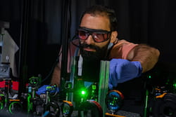 Rice University graduate student Seyyed Ali Hosseini Jebeli works in the laser lab where he and his colleagues confirmed that plasmons can be used to heat one or the other of a pair of electromagnetically linked gold nanoparticles. The ability to control heat at the nanoscale has potential applications in heat-assisted magnetic recording, photothermal therapies and temperature-driven reactivity. (Credit: Jeff Fitlow/Rice University)
