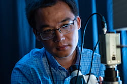 Rice University postdoctoral fellow Qingfeng Zhang and his colleagues revealed in Science their discovery of multilevel chirality in the way bovine serum albumin proteins prompt the 100-nanometer-long particles to align and in the signal they return via circular differential scattering spectroscopy. (Credit: Jeff Fitlow/Rice University)