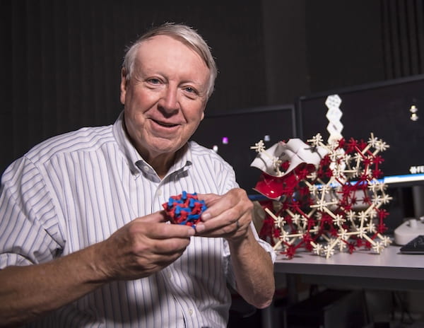 Rice University materials scientist Ned Thomas holds a model of the block copolymer he and his lab created to see if the cubic structures within were perfect or not. Examination with an electron microscope showed distortions in the lattice that could affect their photonic and phononic properties. (Credit: Tommy LaVergne/Rice University) 