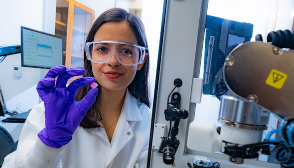 Rice University research scientist Maryam Elizondo holds an engraved bioscaffold 3D-printed for live cells for future implantation. The scaffold encourages the growth of layered tissues as it degrades. (Credit: Jeff Fitlow/Rice University)