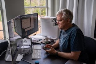 Karl Ecklund, professor of physics and astronomy, prepares his home office for delivering remote instruction. (Photo by Brandon Martin)