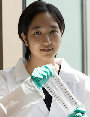 Rice University graduate student Natsumi Komatsu shows a carbon nanotube fiber-enhanced, flexible cotton fabric that turns heat into enough energy to power an LED. Such thermoelectric generators can turn heat from the sun or other sources into energy. (Credit: Jeff Fitlow/Rice University)